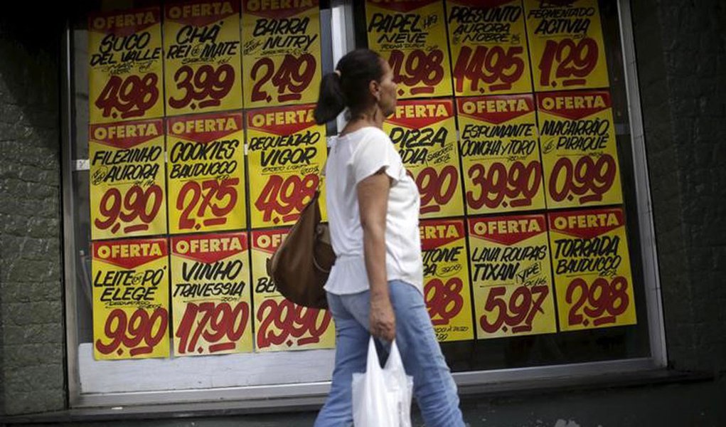 Consumidora passa por cartazes com preços de produtos em mercado no Rio de Janeiro 09/12/2017 REUTERS/Ricardo Moraes