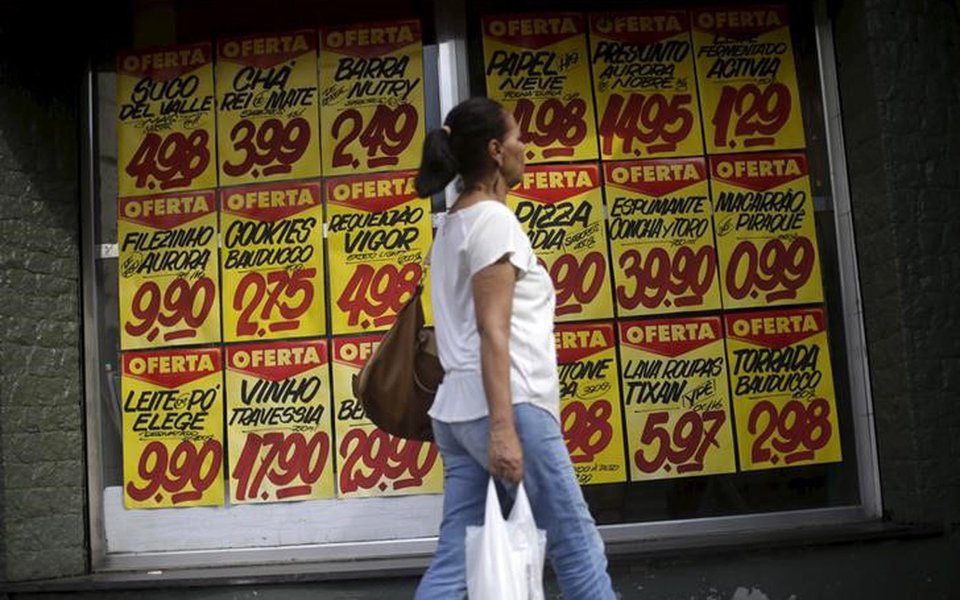 Consumidora passa por cartazes com preços de produtos em mercado no Rio de Janeiro 09/12/2017 REUTERS/Ricardo Moraes