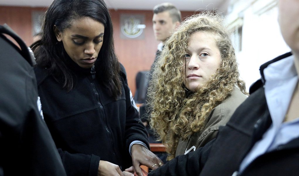 Palestinian teen Ahed Tamimi (R) enters a military courtroom escorted by Israeli Prison Service personnel at Ofer Prison, near the West Bank city of Ramallah, January 1, 2018. REUTERS/Ammar Awad TPX IMAGES OF THE DAY