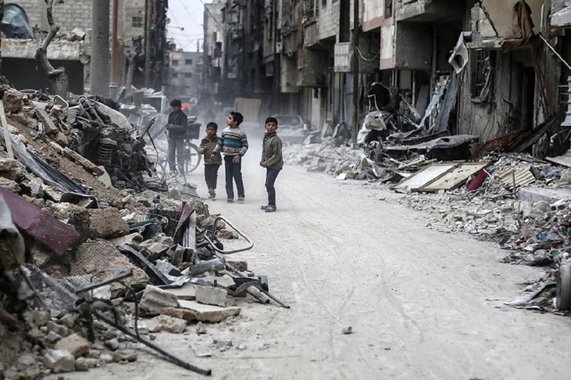 epa05821189 Children stand between the rubble, rebel-held Douma, Syria, 28 February 2017. The rubble are for buildings hit by airstrikes on 25 February 2017. EPA/MOHAMMED BADRA