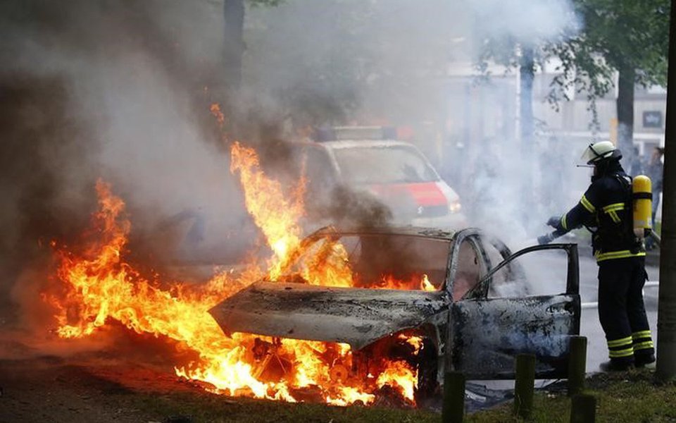Bombeiro apaga chamas em carro em Hamburgo. 07/072017 REUTERS/Hannibal Hanschke T