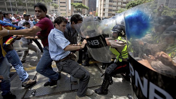 Manifestantes e polícia se enfrentam durante protestos contra o governo de Nicolás Maduro, em Caracas, Venezuela