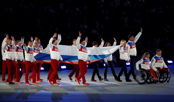 Performers carry the Russian national flag during the closing ceremony of the 2014 Paralympic Winter Games in Sochi, Russia, March 16, 2014. REUTERS/Alexander Demianchuk/File Photo