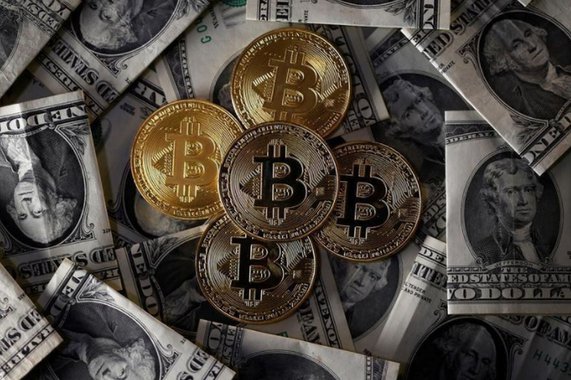 Ilustrações da moeda virtual bitcoin sobre notas de dólar 6/11/2017 REUTERS/Dado Ruvic/Illustration