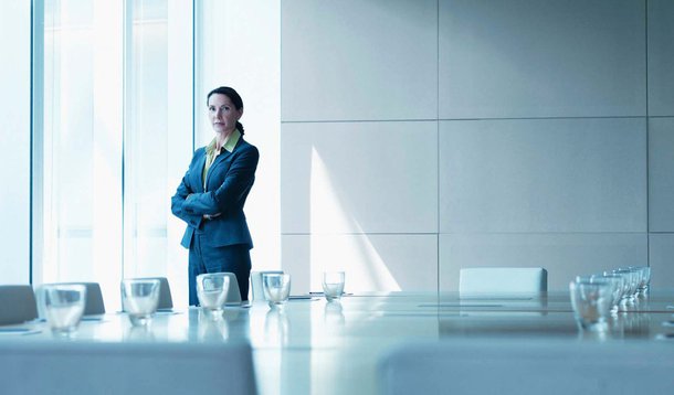 Businesswoman standing alone in conference room