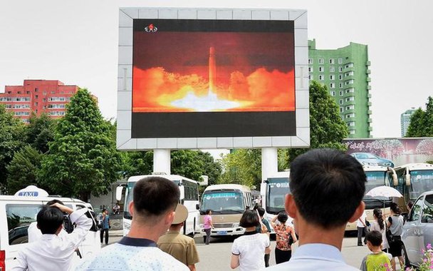 Pessoas assistem à reportagem sobre lançamento de míssil da Coreia do Norte em Pyongyang Kyodo/via REUTERS