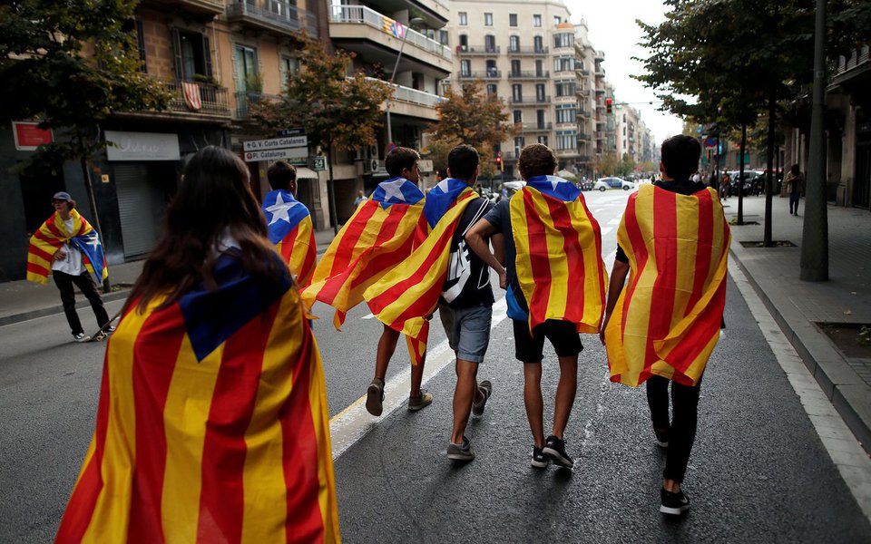 Jovens enrolados em bandeiras separatistas da Catalunha caminham durante protesto em Barcelona 03/10/2017 REUTERS/Jon Nazca