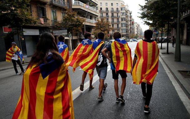 Jovens enrolados em bandeiras separatistas da Catalunha caminham durante protesto em Barcelona 03/10/2017 REUTERS/Jon Nazca