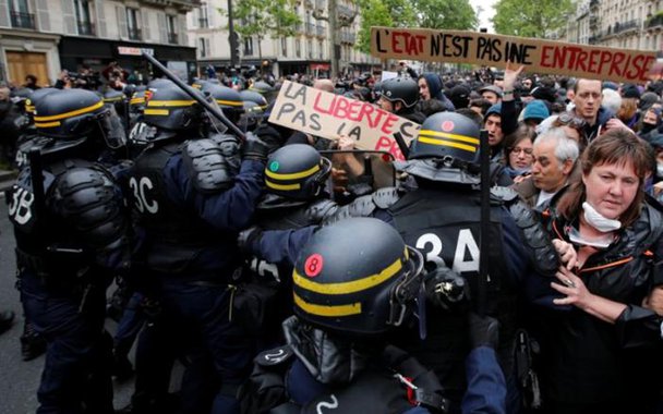 French riot police surround demonstrators who hold a placard with the message, 'The State is not an Company', the day after the country went to the polls, in Paris, France, May 8, 2017. REUTERS/Jean-Paul Pelissier