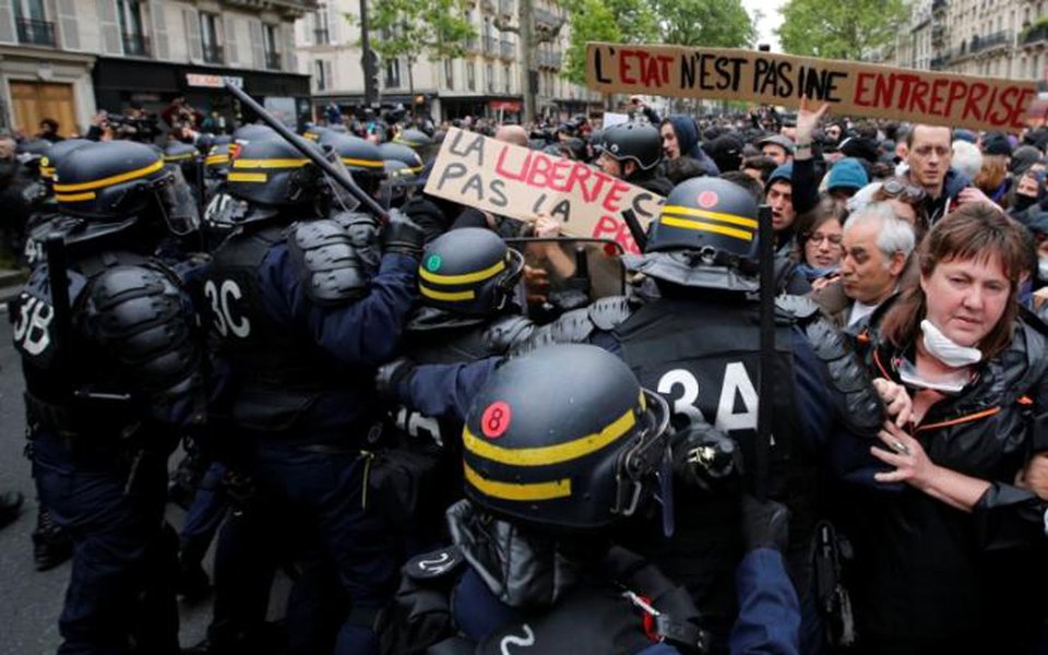 French riot police surround demonstrators who hold a placard with the message, 'The State is not an Company', the day after the country went to the polls, in Paris, France, May 8, 2017. REUTERS/Jean-Paul Pelissier