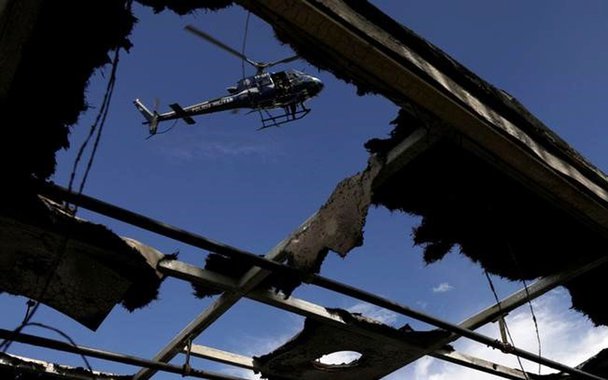 Helicóptero da polícia sobrevoa ônibus queimado perto da comunidade Cidade Alta, no Rio de Janeiro. 02/05/2017 REUTERS/Ricardo Moraes