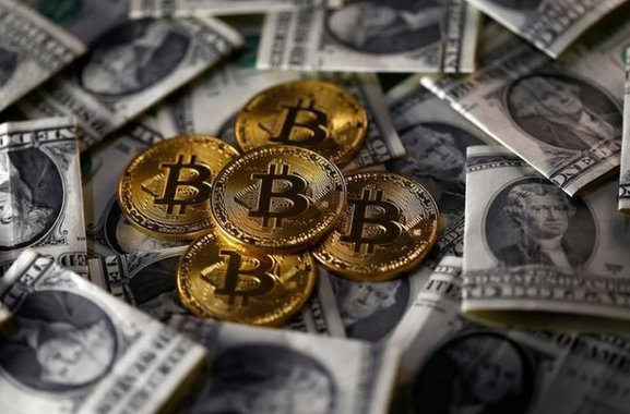 Ilustração da moeda virtual bitcoin sobre notas de dólar 6/11/2017 REUTERS/Dado Ruvic/Illustration