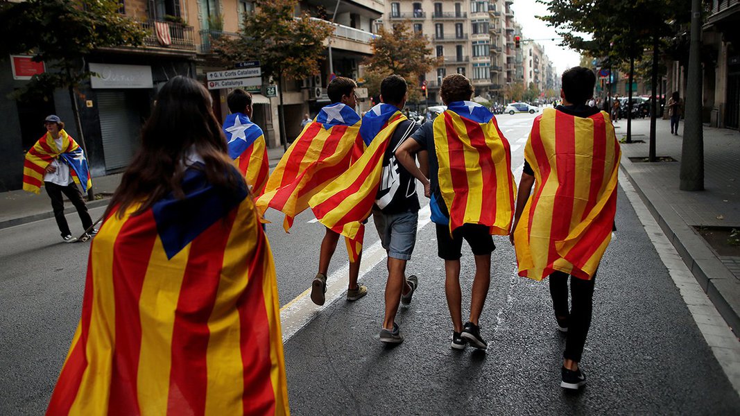 Jovens enrolados em bandeiras separatistas da Catalunha caminham durante protesto em Barcelona 03/10/2017 REUTERS/Jon Nazca