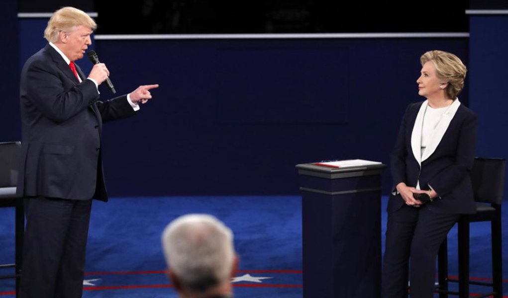 Donald Trump speaks as Hillary Clinton listens. REUTERS/Jim Young