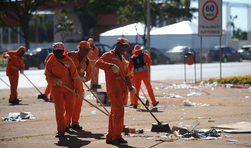 Brasília - Garis recolhem o lixo deixado por vendedores ambulantes e pela população na Esplanada dos Ministérios, após a festa dos 50 anos da capital