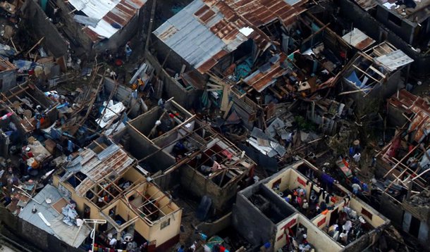 People walk next to destroyed houses after Hurricane Matthew passes Jeremie, Haiti. REUTERS/Carlos Garcia Rawlins