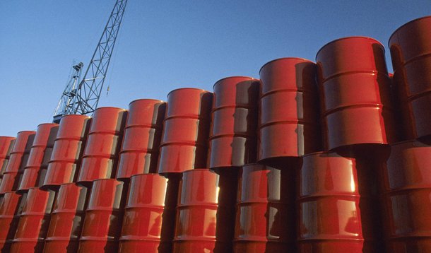Red metal barrels against blue sky.
