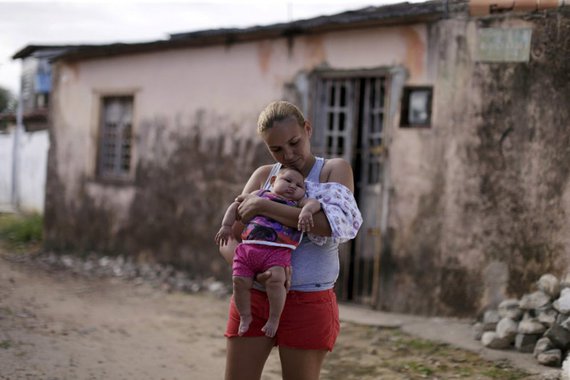 Gleyse da Silva segura a filha com microcefalia diante de sua casa, em Recife. 30/1/2016. REUTERS/Ueslei Marcelino