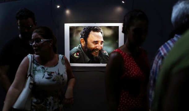 People look at a picture of Cuba's former President Fidel Castro during the opening of the exhibition "Fidel" in Havana, Cuba, August 12, 2016. REUTERS/Alexandre Meneghini