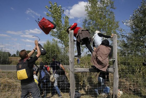 Imigrantes pulando cerca de proteção em Roszke, na Hungria. 09/09/2015 REUTERS/Marko Djurica