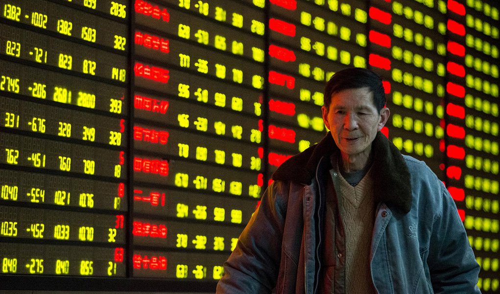 Investidor passa por painel com informaÃ§Ãµes de aÃ§Ãµes em corretora de Nanjing, na China. 11/01/2016 REUTERS/China Daily