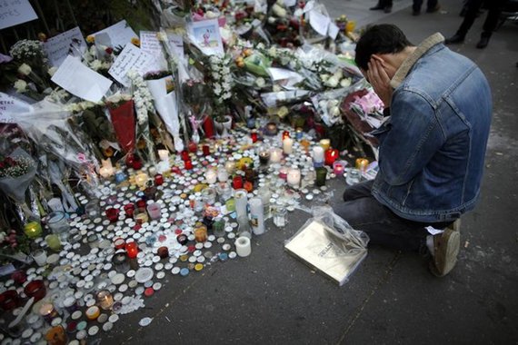 Homem prestando homenagem às vítimas de ataques em Paris. 16/11/2015 REUTERS/Christian Hartmann