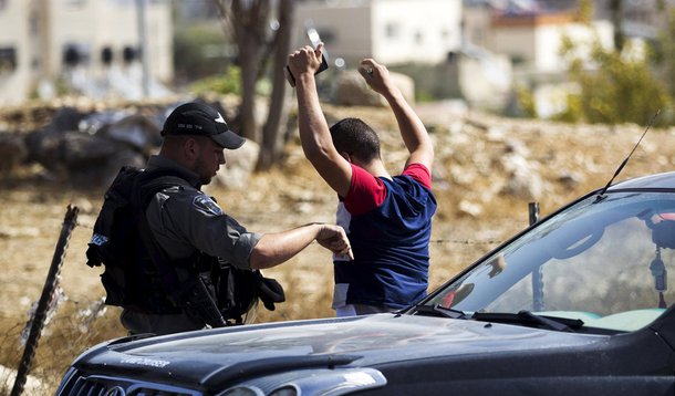 Policial israelense revistando palestino em Jerusalém. 14/10/2015 REUTERS/Ronen Zvulun