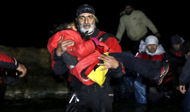 Voluntário leva criança recém-chegada à ilha grega de Chios. 28/01/2016 REUTERS/Giorgos Moutafis