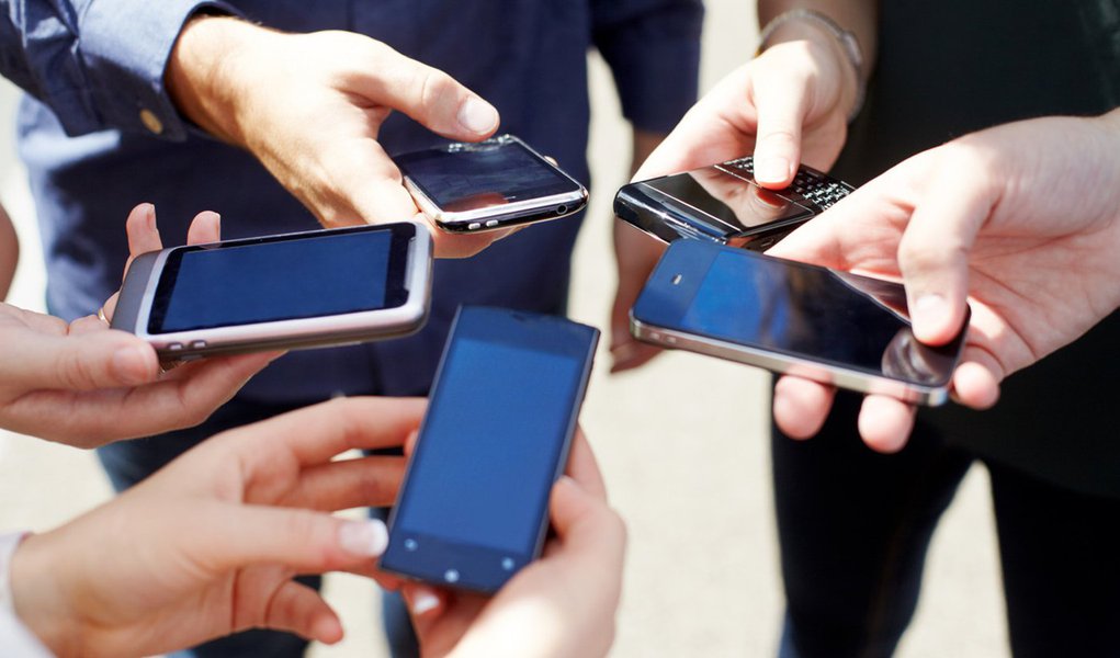 Close up of friends with circle of smart phones.