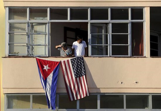 Cubanos colocam bandeira de Cuba e EUA em prédio perto da embaixada norte-americana em Havana. 14/09/2015 EUTERS/Enrique De La Osa