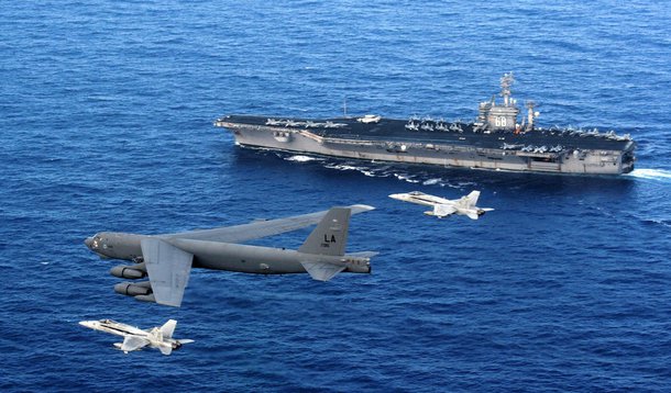 A B-52 Stratofortress flies past the USS Nimitz as two U.S. Navy F/A-18 Hornets intercept. The B-52 is from the 96th Expeditionary Bomb Squadron deployed to Andersen Air Force Base, Guam. (U.S. Navy photo)