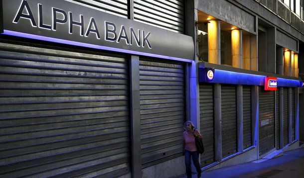 Mulher passa por bancos fechados em Atenas. 12/07/2015 REUTERS/Yannis Behrakis