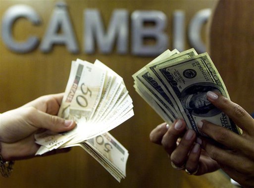 Brasileiro troca reais por dólares em corretora de câmbio no centro do Rio de Janeiro. O dólar fechou em baixa frente ao real nesta terça-feira, interrompendo sequência de duas altas, num pregão marcado por forte volatilidade e novamente com o Banco Centr