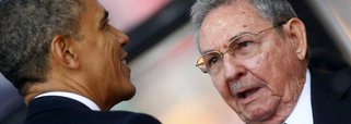 U.S. President Barack Obama (L) greets Cuban President Raul Castro before giving his speech at the memorial service for late South African President Nelson Mandela at the First National Bank soccer stadium, also known as Soccer City, in Johannesburg Decem