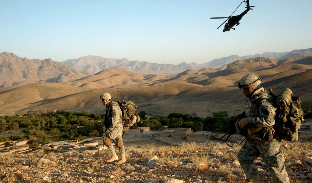 An Apache helicopter provides protection from the air while paratroopers from A Co, 1st Battalion, 325th AIR, move into position shortly after air assaulting into Lwar Kowndalan, Afghanistan to start a five-day mission.