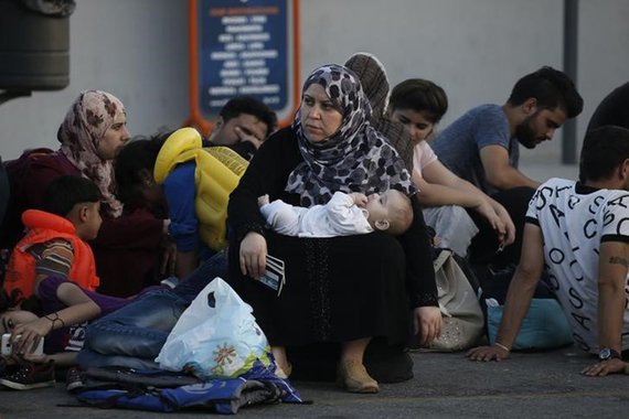 Refugiada síria, com bebê e passaportes, aguarda em porto da ilha grega de Kos. 17/82015 REUTERS/Alkis Konstantinidis