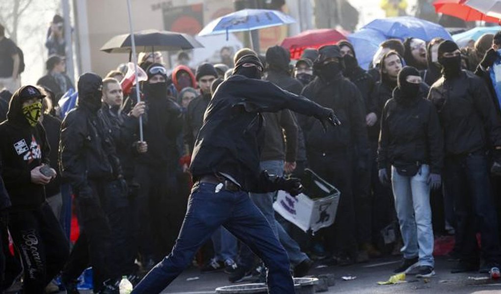 Manifestante joga pedras em policiais em frente a sede do BCE, em Frankfurt.    15/03/2015      REUTERS/Kai Pfaffenbach