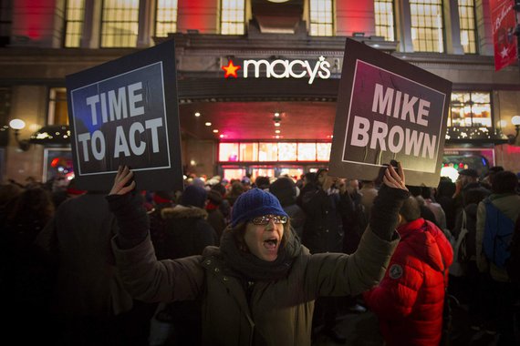 Manifestantes ergue cartazes de protesto em frente a uma loja da rede Macy's, em Nova York. 27/11/2014. REUTERS/Andrew Kelly