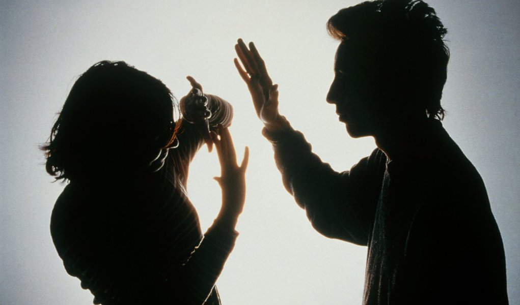 MODEL  RELEASED.    Domestic violence.  Silhouette of a woman protecting herself from a blow from her partner by holding her arms in front of her face.