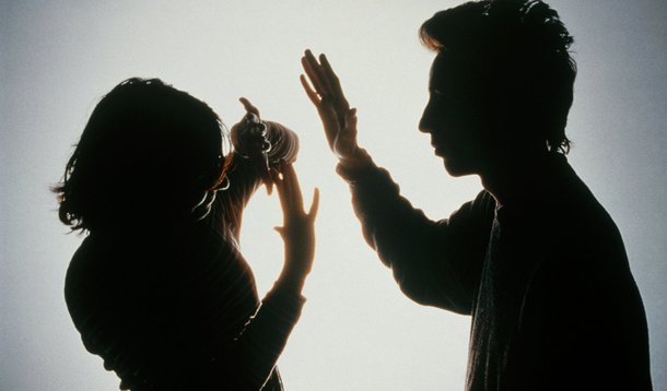 MODEL  RELEASED.    Domestic violence.  Silhouette of a woman protecting herself from a blow from her partner by holding her arms in front of her face.