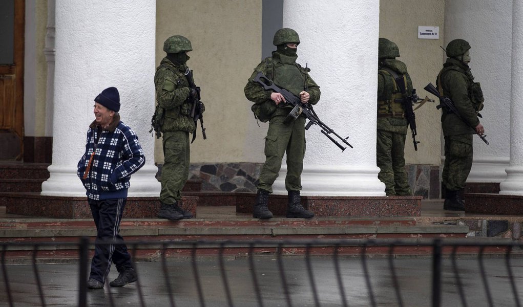 Armed men stand guard at the Simferopol airport in the Crimea region February 28, 2014. Armed men took control of two airports in the Crimea region on Friday in what Ukraine's government described as an invasion and occupation by Russian forces, raising t
