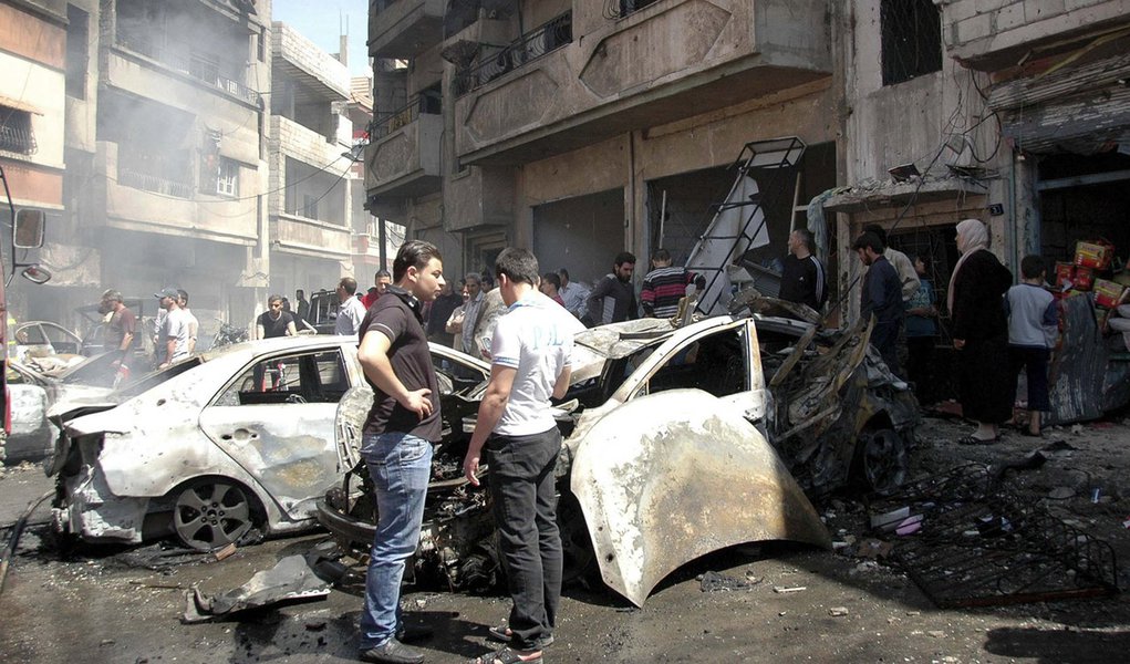 People gather at the site of two car bomb attacks at al-Abassia roundabout in Homs April 29, 2014, in this handout released by Syria's national news agency SANA. Two car bombs killed at least 37 people including women and children near a busy roundabout i