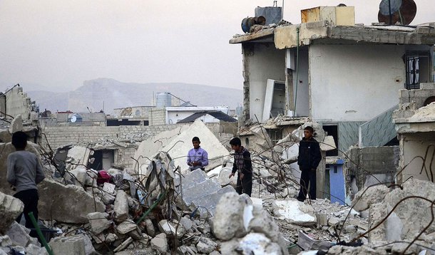 Children walk on rubble of damaged buildings in the Duma neighbourhood of Damascus December 2, 2013. Picture taken December 2, 2013. REUTERS/Yousef Albostany (SYRIA - Tags: POLITICS CIVIL UNREST CONFLICT)
