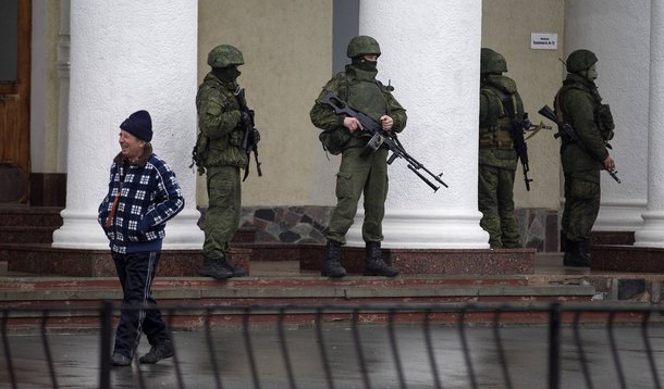 Armed men stand guard at the Simferopol airport in the Crimea region February 28, 2014. Armed men took control of two airports in the Crimea region on Friday in what Ukraine's government described as an invasion and occupation by Russian forces, raising t