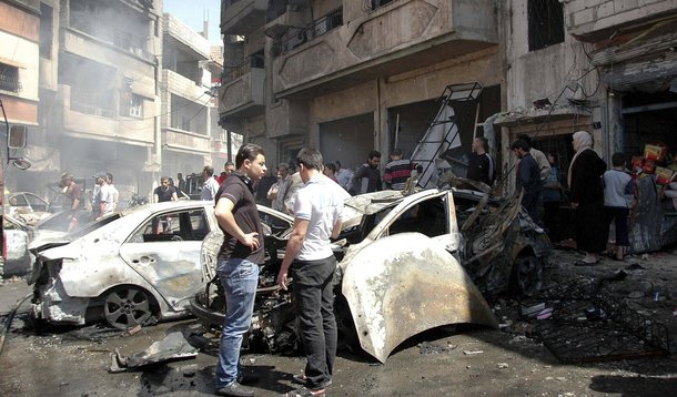 People gather at the site of two car bomb attacks at al-Abassia roundabout in Homs April 29, 2014, in this handout released by Syria's national news agency SANA. Two car bombs killed at least 37 people including women and children near a busy roundabout i