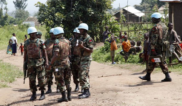 Soldiers from the United Nations intervention brigade exchange information next to a village during a patrol in Virunga National Park in the Democratic Republic of Congo, December 17, 2013. REUTERS/Kenny Katombe (DEMOCRATIC REPUBLIC OF CONGO - Tags: CIVIL