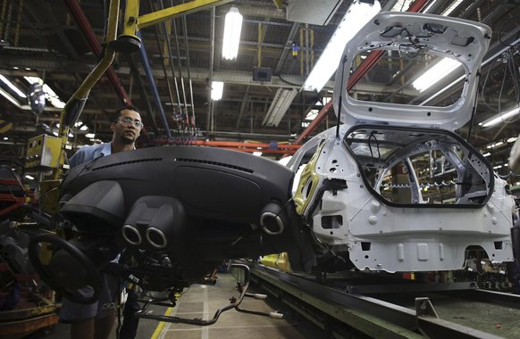 A Brazilian worker assembles a Ford car on an assembly line  at Sao Bernardo do Campo Ford plant, near Sao Paulo August 13, 2013. The pace of vehicle production in Brazil slipped in July to the lowest daily rate in five months as factories, facing sagging