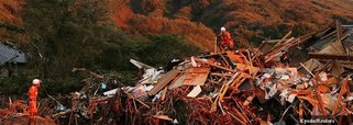 Firefighters search for missing people among collapsed houses following a landslide caused by Typhoon Wipha during sunset on Izu Oshima island, south of Tokyo, in this photo taken by Kyodo October 16, 2013. A typhoon killed 17 people in Japan on Wednesday