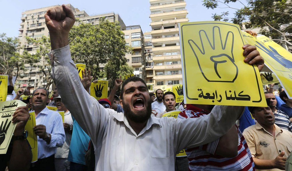 Members of the Muslim Brotherhood and supporters of ousted Egyptian President Mohamed Mursi shout slogans against the military and the interior ministry as they make the "Rabaa" or "Four" gesture, during a protest march towards Mohandessin in Cairo August