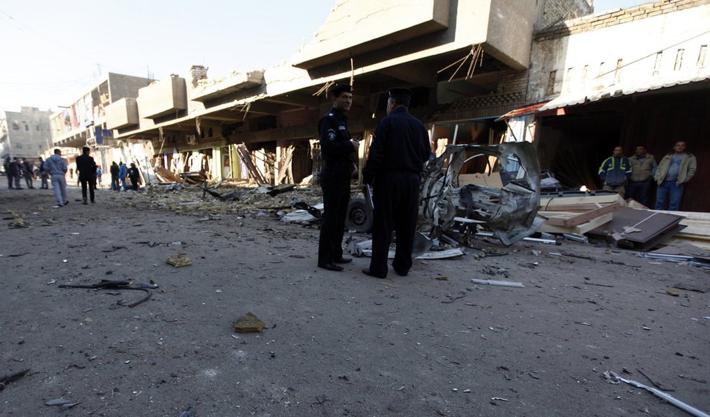 Iraqi policemen inspect the site of car bomb attack in Baghdad December 16, 2013. A series of suicide bombings and car and roadside bombs across Iraq killed at least 17 people on Monday, medical and police sources said. REUTERS/Ahmed Saad (IRAQ - Tags: CI